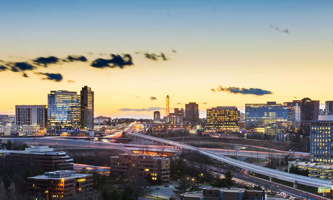 A panoramic city skyline illuminated by warm, golden morning light.
